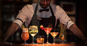 Barkeeper präsentiert verschiedene Cocktails.